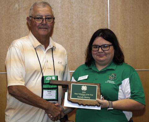 Randy Bailey is named the Oklahoma 4-H Volunteer of the Year at the 4-H Parent-Volunteer Conference at Oklahoma State University. Presenting the award is Mandy Schroeder, immediate past-president of the 4-H Volunteer Board. Photo courtesy Mitchell Alcala, OSU Agriculture
