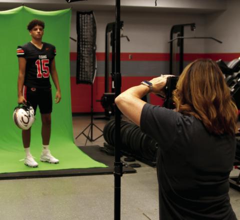 Brandy Moton, of Moton Photography, gets a set of photos of Cushing Senior Kamarion Franklin inside the Tiger weight room during Cushing’s Media Day on Saturday. Photo by J.D. Meisner