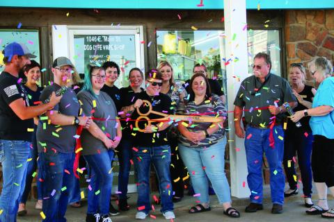 Surrounded by friends and fellow Cushing Chamber of Commerce members, Tera Schooley, owner of Dig Lyfe Vapor Co., wields the scissors at the ribbon cutting and grand re-openeing celebrating Dig Lyfe Vapor's new location at 1046 E Main Street, Thursday, July 18. Photo by Allie Prater.