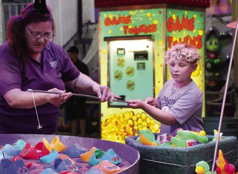 Haskel Travis, of Perkins, concentrates as he tries to hook a fish at a carnival game during the Payne County Free Fair. Photo by Allie Prater