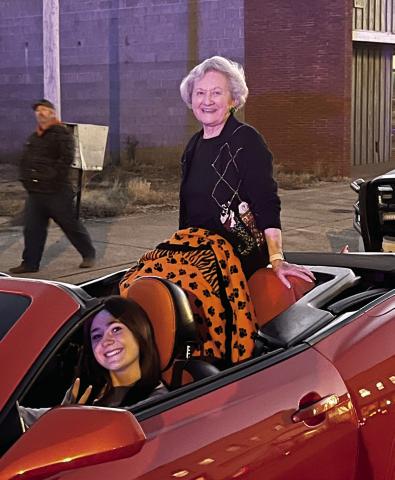 Parade Grand Marshall Marilyn Duff sits atop a red Camaro driven by Romy Withiam. Photo Courtesy Marilyn Duff.