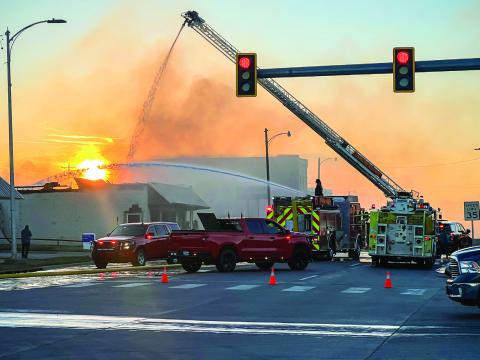 A Cushing firefighter sprays water from the top of the ladder of Truck-1, while another directs a stream of water from Engine 2 during the later phases of the firefight at the abandoned laundromat at 409 E. Main. The structure was destroyed, and no injuries were reported. More fire photos inside. Photo by J. D. Meisner
