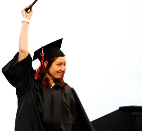Kirsten Kitchen-Hill holds her diploma high as she crosses the stage at Friday’s Cushing High School graduation ceremony.