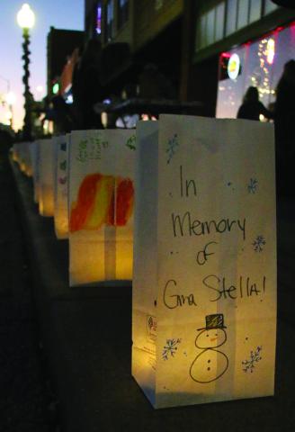 Memorial luminarias light the way for revelers on Broadway, Saturday as individuals and businesses purchased the lantern kits from DCRA members in honor of loved ones. Photo by Allie Prater