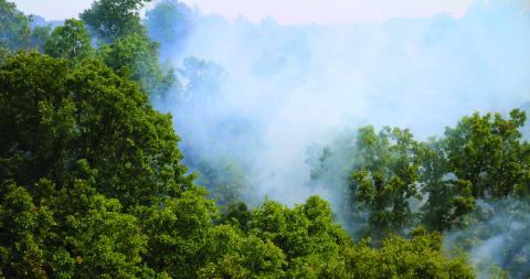 The valley of Rocky Canyon Ranch near 401st smolders during a prescribed burn Friday, Aug. 9. Photo By Allie Prater.
