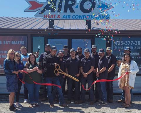 Air-O Owner Chris Vasquez cuts the sash during the ribbon cutting ceremony for the business held on April 11. Cushing Chamber of Commerce officials, local business owners, and employees stand together to celebrate the event.
