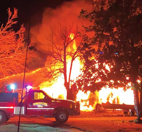 Firefighters battle a blaze in Tryon that involved two houses and an out building Monday.