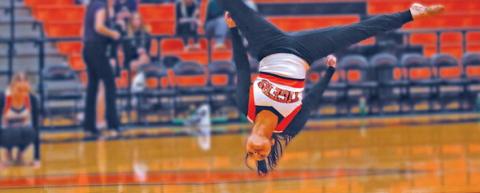 Lindy Candler performs a tumbling pass during the Tiger Dance Team’s performance at halftime of the boys game against Mannford. See story inside. Photo by J.D. Meisner.