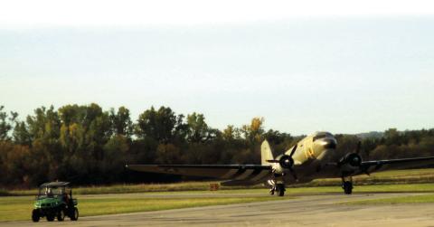 Airport Manager Mike Middleton leads a C-47 to to the tarmac at the Cushing Municipal Airport during the Fly-in and Fun Fair held last fall. Photo by J. D. Meisner