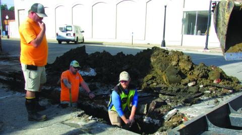 City crew members Daniel Burt and Justin Mosher dig in the dirt to replace a waterline on South Harrison Avenue from Cherry Street to Broadway while Billy Hickman supervises and Steven James works construction equipment to clear away debris last Wednesday on Sept. 4. Burt said there would be further work due to future street and sidewalk renewals that are planned. Photo by DeAnna Maddox