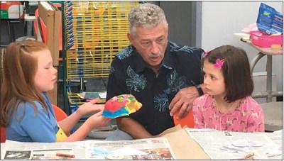 Representative John Talley discusses how to make a mask with Hadley Marshall (left) and Piper Sigle during the last week of the most recent Cushing Art Camp held at Cushing Middle School.