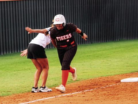 Ava Hepensberger gets a little love from head coach Nikki York as she rounds third after crushing a homer over the left field fence. Photo by Dallas Lauderdale