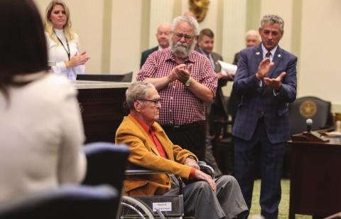 WWII veteran Sgt. Burton Richard Coate on the fl oor of the Oklahoma House of Representatives with his son Richard Coate and Rep. John Talley.
