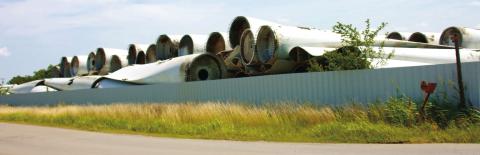 Hundreds of discarded wind turbine blades stacked like cordwood at a site south of Cushing await their fate. Photo by J.D. Meisner