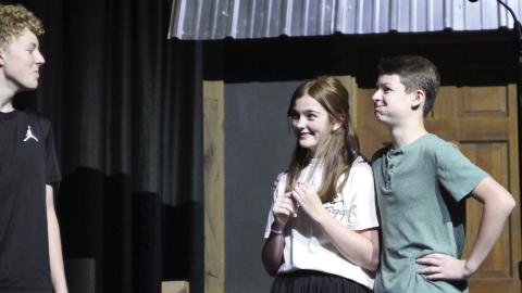 Harper Beasley as Tevye, Evi Bussell as Tzeitel, and Kyzer Gaither as Motel rehearse a scene of “Fiddler on the Roof Jr.” during the Cushing Theatre Camp on July 17. After being directed that “he was supposed to be in love” by Kristin Tarp, Gaither hurriedly placed his arm around Bussell and held back a laugh.