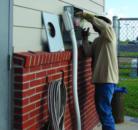 Allegiant Utility Services’ tech Quan Pugh at the Cushing Animal Shelter installing the first new AMI meter. Photo by DeAnna Maddox