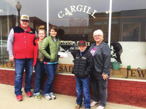 Pictured with the new sign on the windows of their new shop are Justin and Brooke Cargill with their daughter Mercedes and son Beau. At right is DCRA Treasurer Beth Dutton.