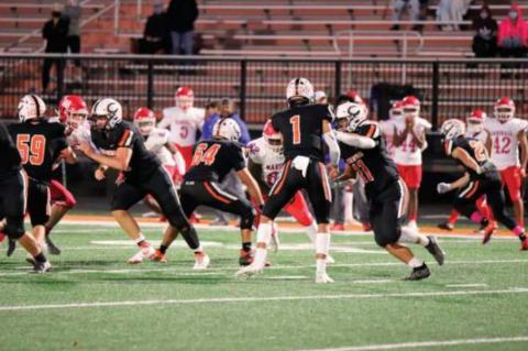 Blaze Berlowitz hands offthe Haden Fry during the Tigers 21-6 win over the John Marshall Bears. Fry had 34 carries for 250 yards and two touchdowns Thursday.