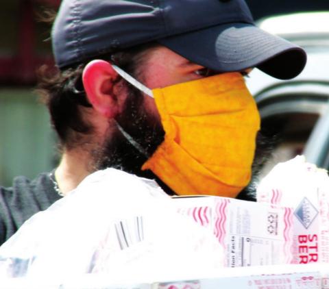 Custom Signs employee Paul Miller volunteers to distribute food at a food bank in April, 2020, outside of Custom Signs, in Cushing. Volunteers distributed groceries to more than 350 cars and over 400 families struggling to make ends meet during the COVID-19 economic shutdown in April.