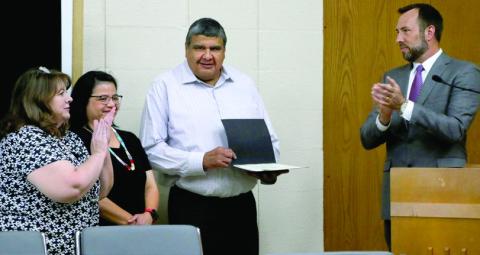 City of Cushing employee Brett Youngman stands with his wife Lavonda after he is presented with a team member recognition award by Tracy Rose from Oklahoma Municipal League and Commission Chairman B.J. Roberson during the commission meeting Monday, June 17, Photo by Allie Prater.