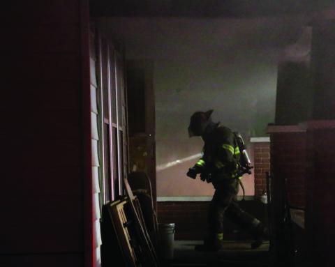 A member of the Cushing Fire Department re-enters the structure.