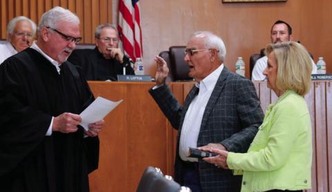 Winetta Lamb holds a family bible for her husband Ron as Municipal Judge Bill Ahrberg administers the oath of office to newly elected commissioner Ron Lamb. Photos by J.D. Meisner