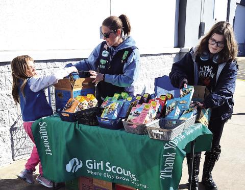 Local Girl Scout Troop 790 set up to sell cookies just outside Wal-Mart Sunday, Feb. 22, offering classic favorites to passersby during the annual cookie season fundraiser. Pictured from left: RayLynn Floyd, Troop Leader Rebecca Green, and Alice Green. Photo by DeAnna Maddox