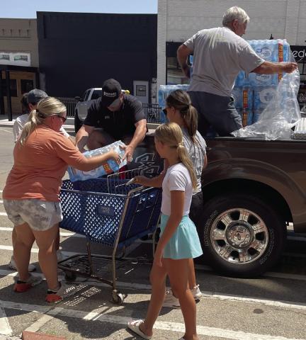 Rotarian John Rhoten and other community volunteers unload a pallet of water at the Cimarron Towers in Downtown Cushing Tuesday, Aug. 6. Photo courtesy Nancy Dowell