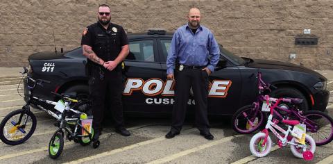 Cushing Police department Officer Wright and Detective Livergood stand with the first four bicycles purchased for the upcoming Bicycle Rodeo.