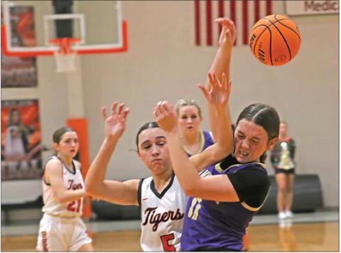 Whoever said basketball is not a contact sport never watched these girls play. Mannford’s Cambri Casey takes an elbow to the chin from Cushing’s Remi Powell as both girls battle for a rebound. Photo by J.D. Meisner