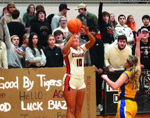 Katy Jones puts up a three pointer from the corner as members of “The Jungle” Cushing’s notorious student section, put their own energy into the shot.