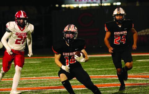 Cushing safety Carl Peterson looks for a seam after intercepting a Skiatook pass Friday in the Tigers’ 61-7 thrashing of the Bulldogs. Backing up Peterson is Cushing freshman linebacker Cody Robinson. Cushing will host Sallisaw this Friday in the opening round of the OSSAA Class 4A state tournament. Photo by J.D. Meisner