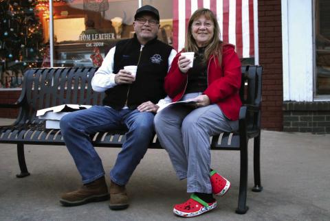 Jim and Shellie Walker enjoy a cup of hot apple cider during the inaugural Downtown Cushing Revitalization Association (DRCA) Cookie Crawl held Tuesday, Dec.12. Seventeen businesses participated in the Cookie Crawl and 92 boxes of cookies were sold. Photo by Allie Prater