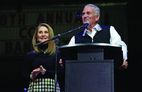 Husband and wife share a laugh with the crowd as Kris Kinzie reads through Denise Kinzie’s favorite quote from Margaret Thatcher: “If you want something said, ask a man; if you want something done, ask a woman”. Photo by DeAnna Maddox