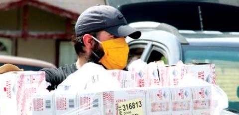 Custom Signs employee Paul Miller volunteers to distribute food Wednesday.