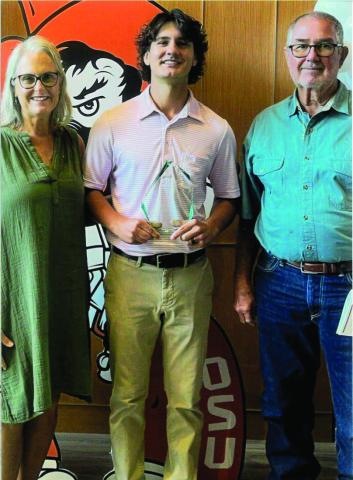 Tricia and Ray McGinnis present Coleton Dallas the Scott A. McGinnis Memorial Scholarship.