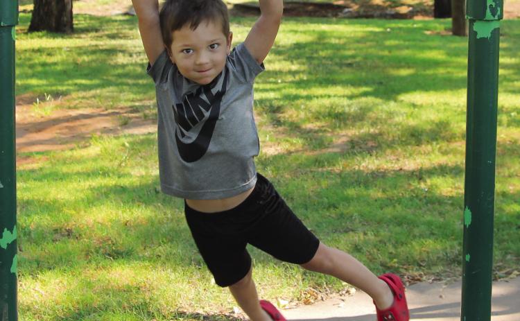 Before starting preschool at Oak Grove, Jack McDougal was at Memorial Park this Tuesday to conquer the monkey bars; a feat his granny and gramps said every young boy needed to achieve. He managed a jump and catch of the bar and even a bit of a swing. His sister had her own version — running under the bars with her hands raised. Photo by DeAnna Maddox
