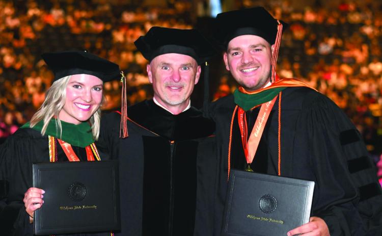 Brooke Gardner and Bingham Hightower stand with their father, Dr. Brian Hightower, between them after they officially earn the title of doctor themselves. Photo courtesy Dr. Brian Hightower.