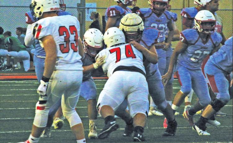 Sophomore strongman Nicolas Flores takes on two Chisolm linemen.