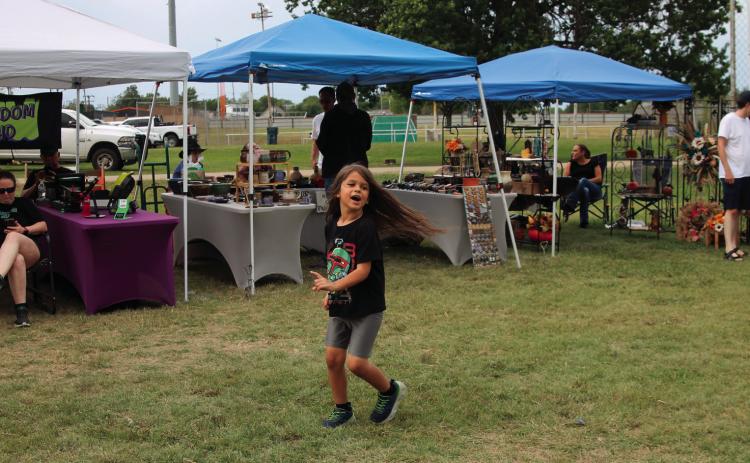 Matthew Carpenter made his own fun in between Festival in the Park performances by spinning in circles as fast as he could. It may have been slower than the Whirly Bird across the way but it was a lot less arm work as well. Photos by DeAnna Maddox