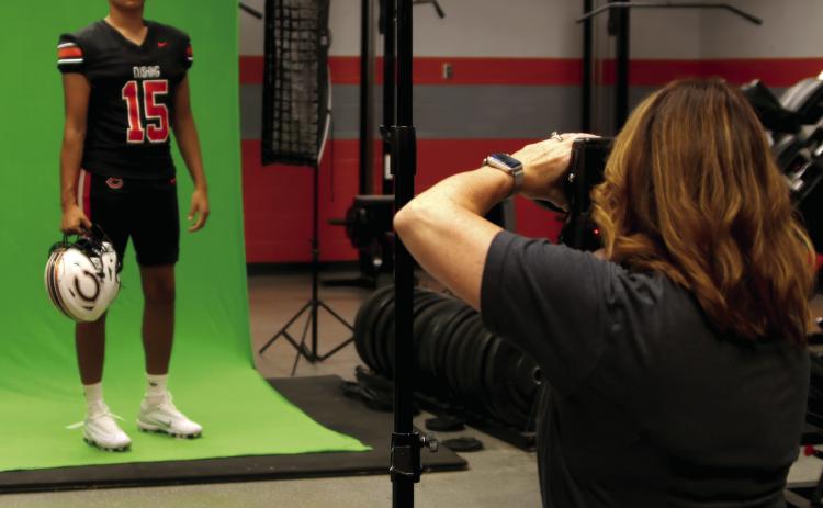 Brandy Moton, of Moton Photography, gets a set of photos of Cushing Senior Kamarion Franklin inside the Tiger weight room during Cushing’s Media Day on Saturday. Photo by J.D. Meisner