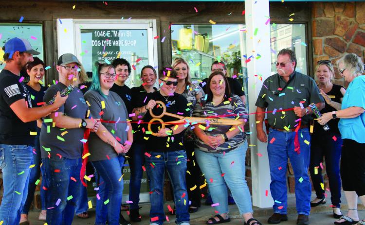 Surrounded by friends and fellow Cushing Chamber of Commerce members, Tera Schooley, owner of Dig Lyfe Vapor Co., wields the scissors at the ribbon cutting and grand re-openeing celebrating Dig Lyfe Vapor's new location at 1046 E Main Street, Thursday, July 18. Photo by Allie Prater.