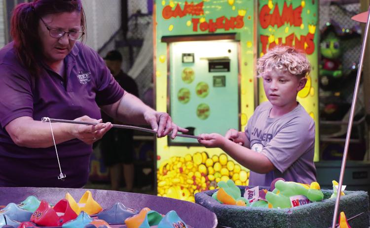 Haskel Travis, of Perkins, concentrates as he tries to hook a fish at a carnival game during the Payne County Free Fair. Photo by Allie Prater