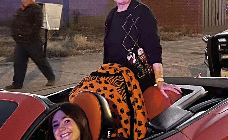 Parade Grand Marshall Marilyn Duff sits atop a red Camaro driven by Romy Withiam. Photo Courtesy Marilyn Duff.