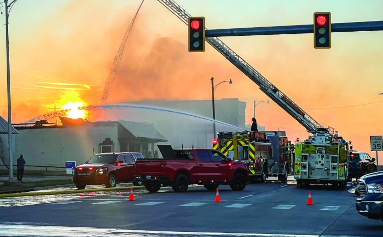 A Cushing firefighter sprays water from the top of the ladder of Truck-1, while another directs a stream of water from Engine 2 during the later phases of the firefight at the abandoned laundromat at 409 E. Main. The structure was destroyed, and no injuries were reported. More fire photos inside. Photo by J. D. Meisner