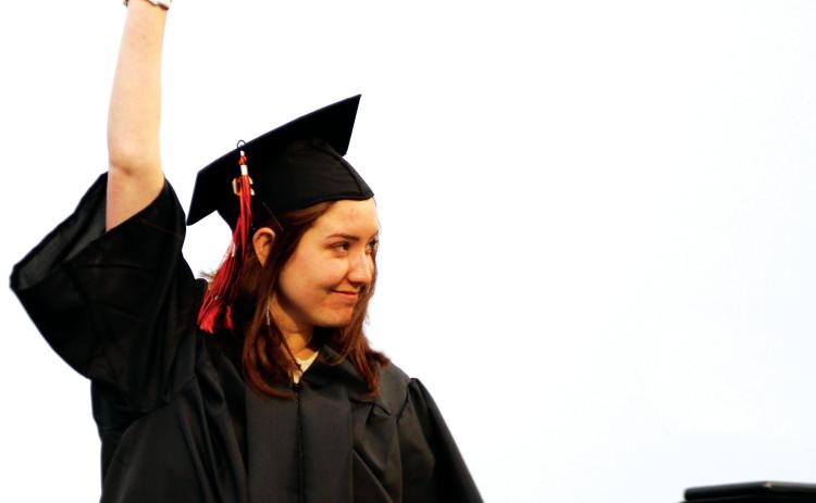 Kirsten Kitchen-Hill holds her diploma high as she crosses the stage at Friday’s Cushing High School graduation ceremony.