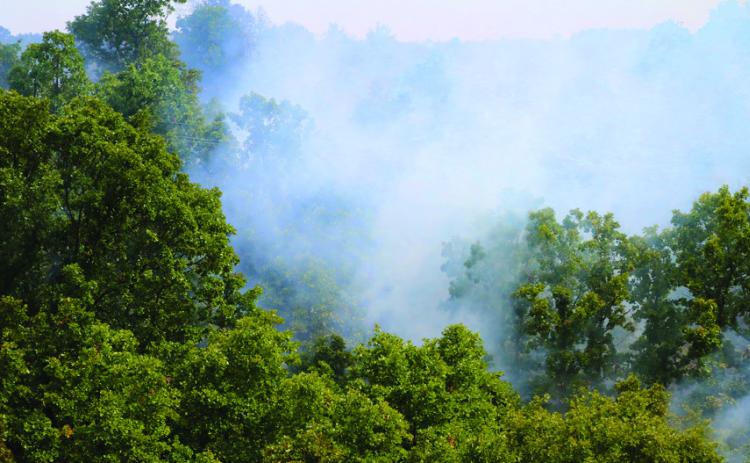 The valley of Rocky Canyon Ranch near 401st smolders during a prescribed burn Friday, Aug. 9. Photo By Allie Prater.