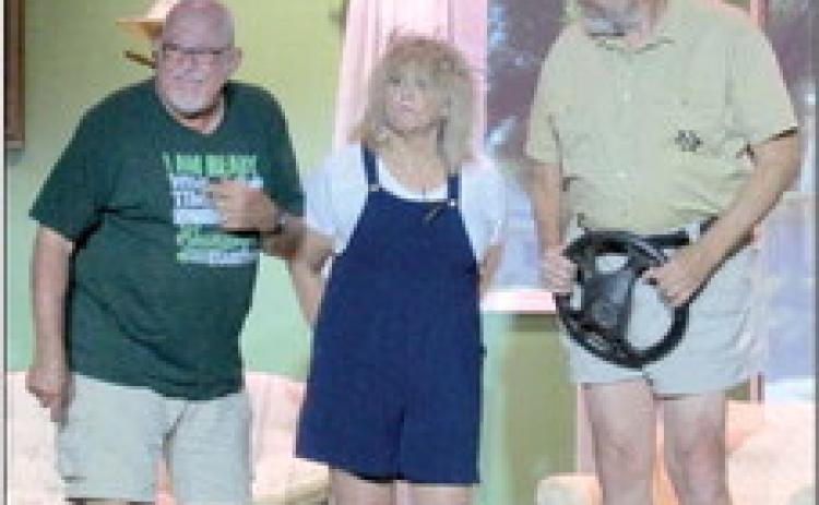 Sheriff Grover Lout (Brett Anderson) catches up with LaMerle Verdeen Minshaw (Michele Music) after a failed attempted to flee while Aubrey Verdeen (Bob Lynch) cracks another joke as the Cushing Community Theatre’s performance of “The Red Velvet Cake War” comes to an end.