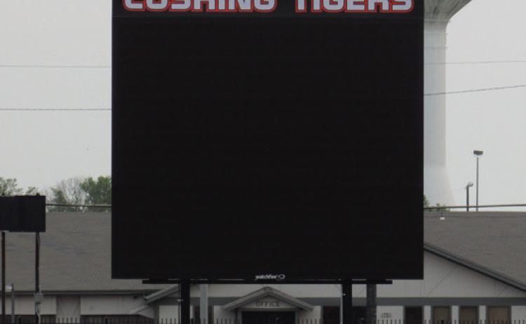 Students race across the football field in front of the recently installed Jumbotron at O’Dell Field. The digital video board will be enhancing Friday nights and other field events with live video, score board display, and eventually instant replays.