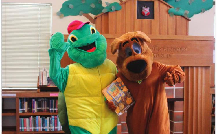 Beloved children’s book characters, Scooby-Doo and Franklin the Turtle, hold one of the many books available at the Cushing Public Library.